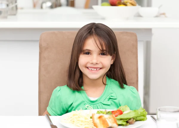 Porträtt av en liten flicka som äter pasta och sallad — Stockfoto