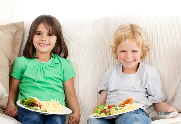 Feliz irmão e irmã tendo jantar na TV — Fotografia de Stock