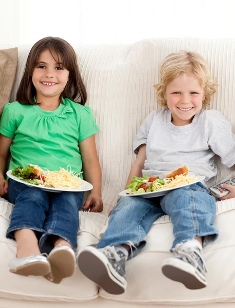 Felice fratello e sorella guardando la televisione mentre si mangia la pasta — Foto Stock