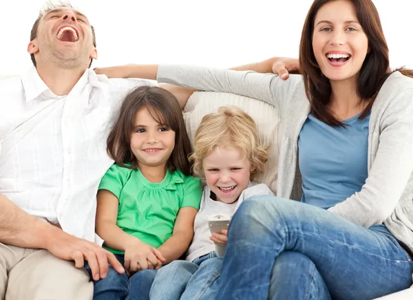 Famille riant tout en regardant la télévision ensemble — Photo