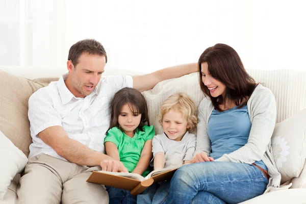 Happy family looking at a photo album together — Stock Photo, Image