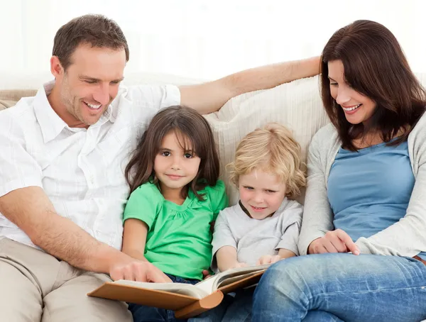 Cute girl and her family looking at a photo album — Stock Photo, Image