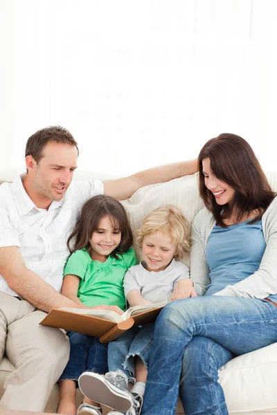 Familia alegre mirando un álbum de fotos juntos —  Fotos de Stock