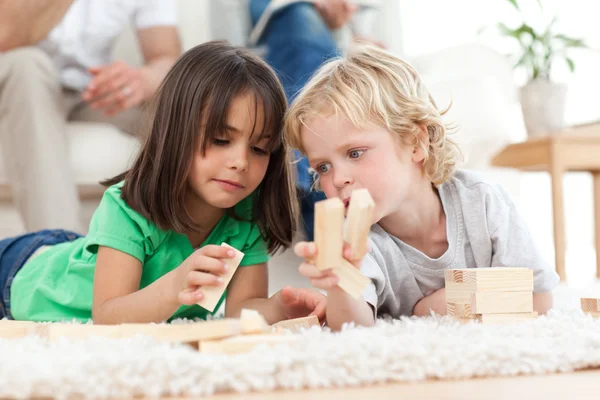 Маленький хлопчик і дівчинка граються з доміно разом — стокове фото