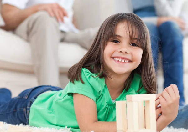 Aranyos kis lány játék a dominó a nappaliban — Stock Fotó