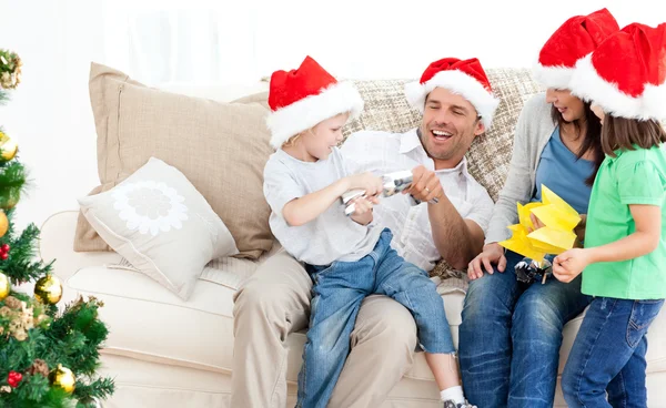 Vater und Sohn spielen mit einem Cracker auf dem Sofa — Stockfoto