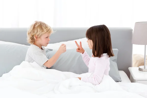 Cute brother and sister playing rock paper and scissors on their — Stock Photo, Image