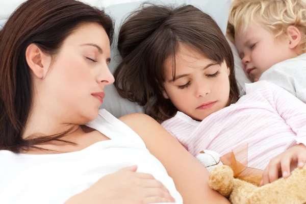 Adorable brother and sister sleeping with their mother in her be — Stock Photo, Image