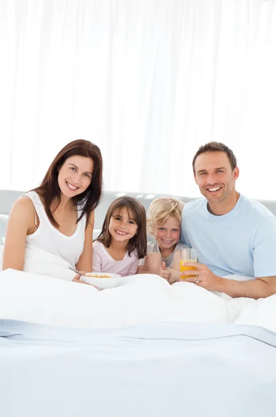 Happy brother and sister having breakfast with their parents on — Stock Photo, Image