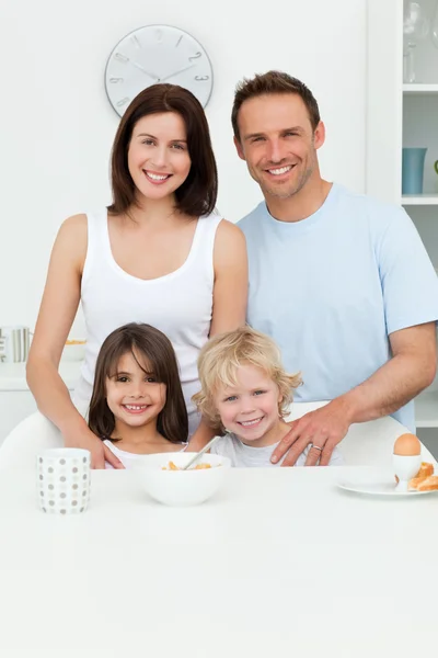Счастливые родители позируют со своими детьми на кухне — стоковое фото