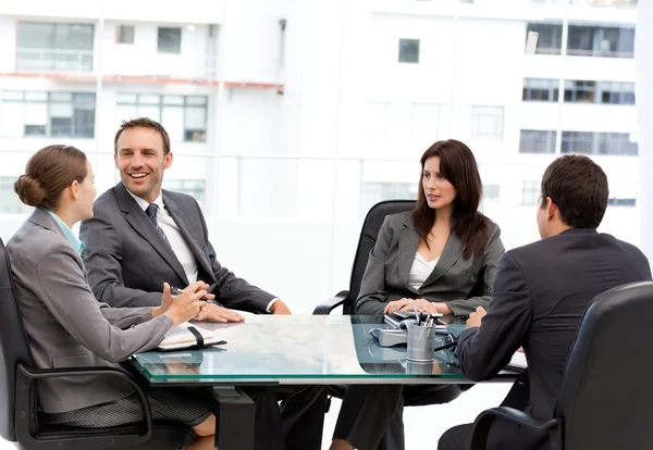 Bonito gerente rindo durante uma reunião com sua equipe — Fotografia de Stock