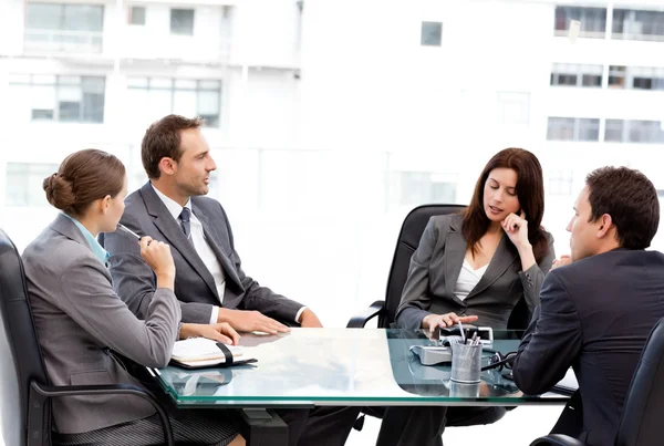Mulher de negócios atenciosa conversando com sua equipe durante uma reunião — Fotografia de Stock