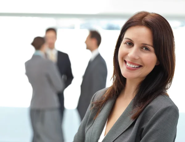 Hübsche Geschäftsfrau posiert während der Arbeit vor ihrem Team — Stockfoto