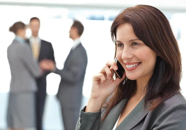 彼女のチームが働いている間電話で幸せな女性実業家 — ストック写真