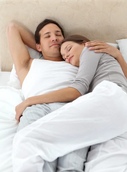 Nettes Paar schläft sich in den Armen auf dem Bett — Stockfoto