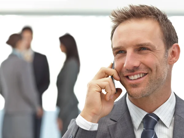 Glücklicher Geschäftsmann am Telefon während eines Treffens — Stockfoto