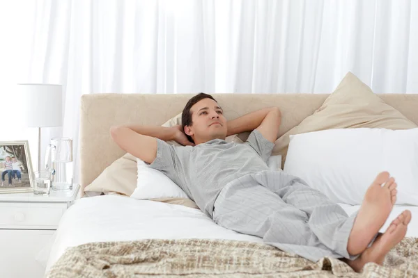Pohledný muž relaxační na posteli — Stock fotografie