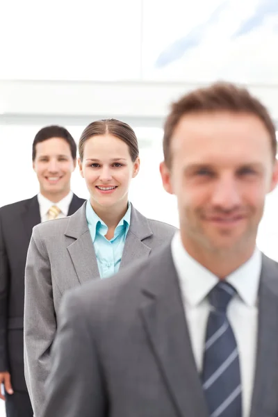 Young businesswoman posing with two businessmen in a row — Stock Photo, Image