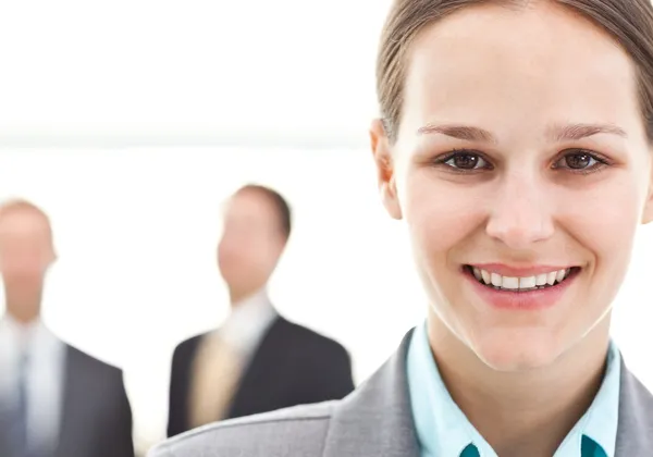 Junge Geschäftsfrau posiert vor zwei Geschäftsleuten — Stockfoto
