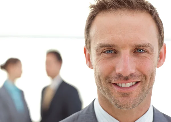 Cheerful businessman posing in front of his team while working — Stock Photo, Image