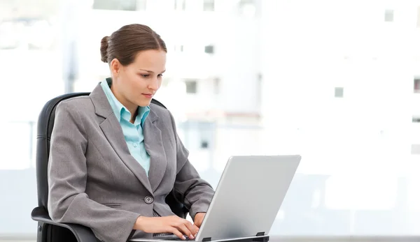Bonita mulher de negócios trabalhando no laptop sentado em sua mesa — Fotografia de Stock