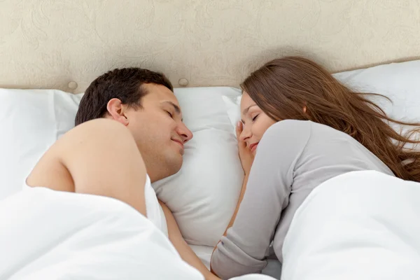 Gelassenes Paar, das zusammen auf ihrem Bett schläft — Stockfoto