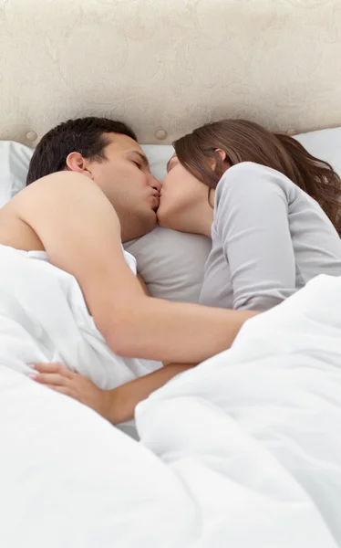 愛らしいカップルはベッドでリラックスしながらのキス — ストック写真