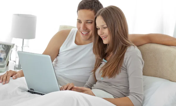 观看视频，在笔记本电脑上的年轻夫妇 — 图库照片