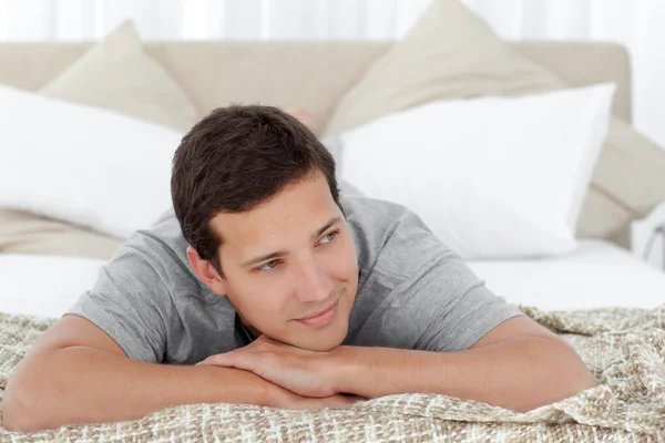 Mutlu adam yatağının kenarında yatan — Stok fotoğraf