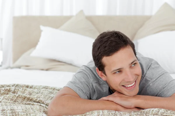 Веселый мужчина лежит в своей спальне — стоковое фото