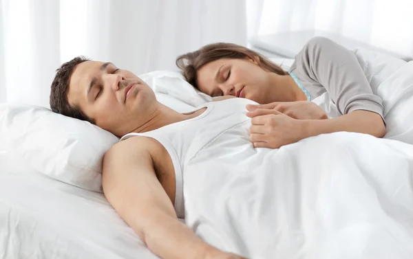 Couple mignon dormant ensemble sur leur lit — Photo