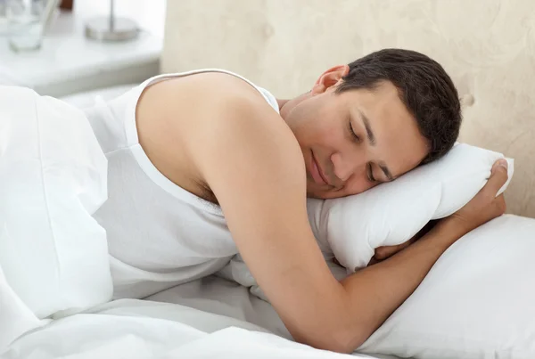 Netter Mann, der friedlich auf seinem Bett schläft — Stockfoto