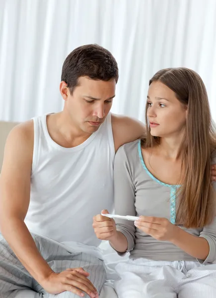 Man looking at a pregnancy test with his girlfriend — Stock Photo, Image