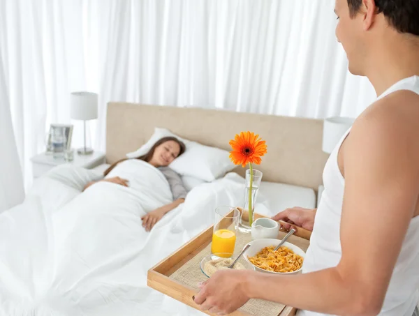 Красивый мужчина приносит завтрак своей девушке — стоковое фото