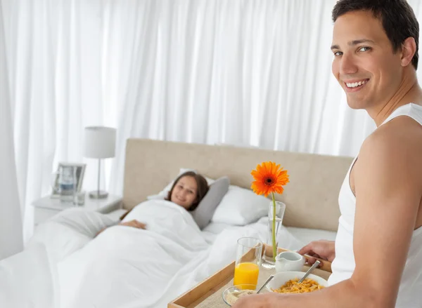 Glücklicher Mann, der seiner Freundin das Frühstück auf dem Bett bringt — Stockfoto