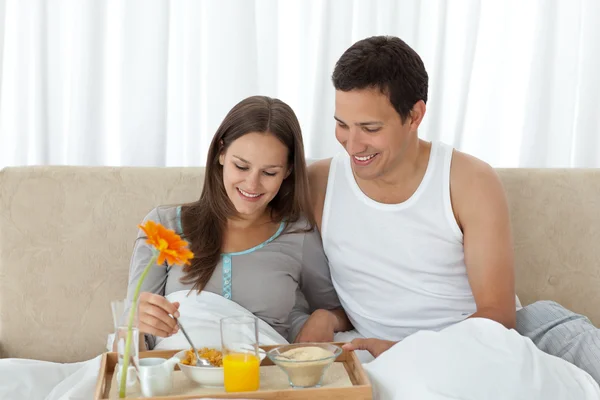 Junge Frau frühstückt mit ihrem Freund auf dem Bett — Stockfoto
