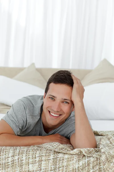 Porträt eines fröhlichen Mannes, der auf seinem Bett liegt — Stockfoto