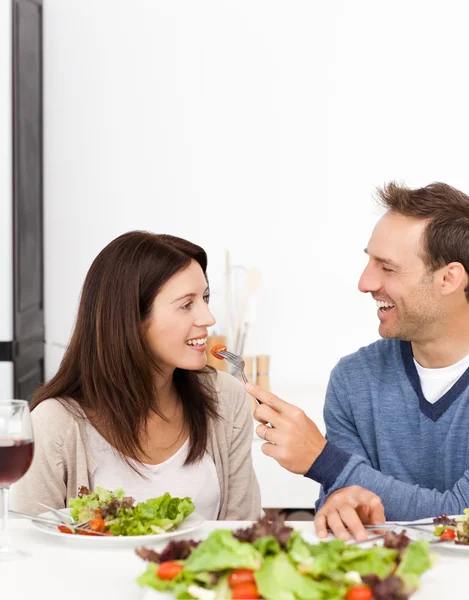 Homem dando um tomate para sua namorada enquanto almoça — Fotografia de Stock