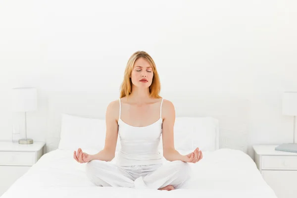 Kobieta praktyki jogi na jej łóżko — Zdjęcie stockowe