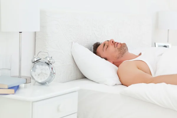 깨어나 전에 자신의 침대에서 편안한 남자 — 스톡 사진