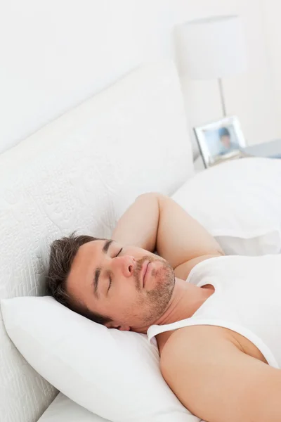 Расслабленный человек в постели, прежде чем проснуться — стоковое фото