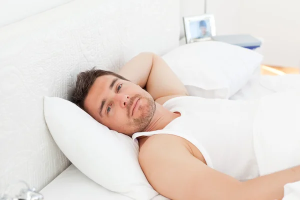 En avslappnad man i hans säng innan vakna — Stockfoto