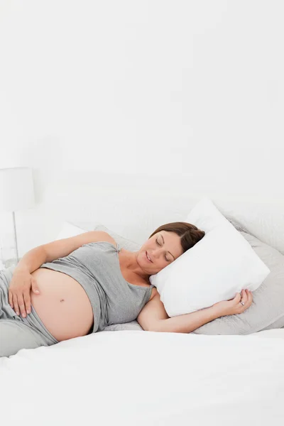 Беременная женщина на кровати — стоковое фото
