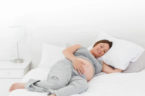 怀孕的女人，在她的床上 — 图库照片