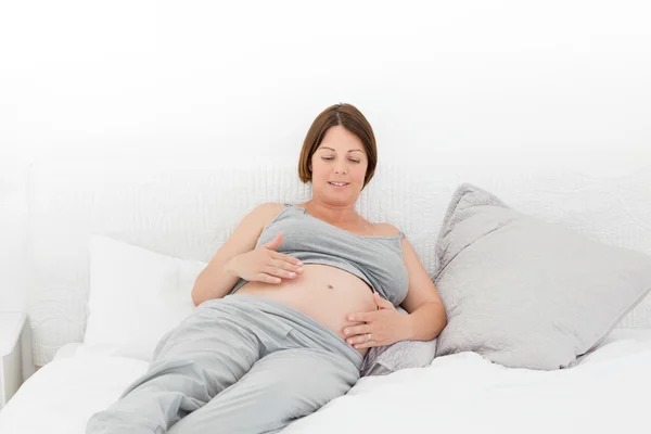 Těhotná žena mazlení její břicho — Stock fotografie