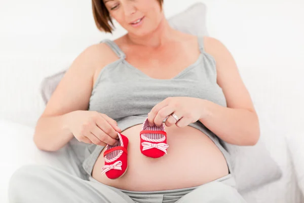 Έγκυος γυναίκα με παιδικά παπούτσια — Φωτογραφία Αρχείου