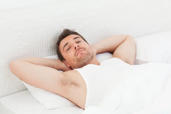 Ein entspannter Mann in seinem Bett vor dem Aufwachen — Stockfoto