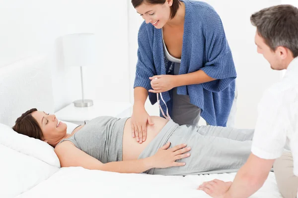 Kobieta w ciąży z mężem i pielęgniarki — Zdjęcie stockowe