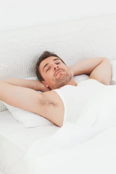 En avslappnad man i hans säng innan vakna — Stockfoto