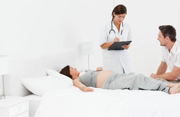 Беременная женщина с мужем и медсестрой — стоковое фото